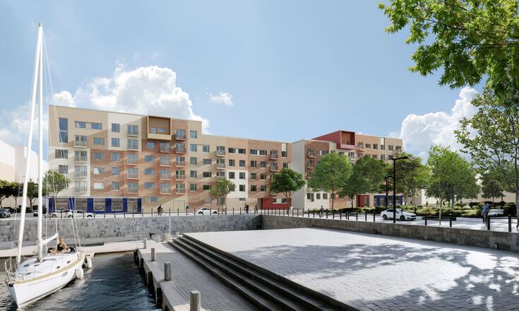 Vaaleansävyinen monimuotoinen kerrostalo lähellä kanavaa.