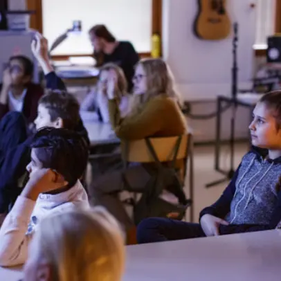 Lapset katsovat opetusvideoita yhdessä luokkahuoneessa.