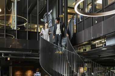 Kuvituskuva, jossa ihmisiä kierreportaissa.