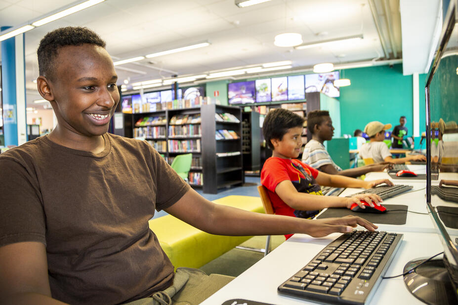 Young people playing video games in a library