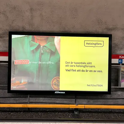 700 000 helsinkiläistä -kampanjan ulkomainos metrotunnelissa.