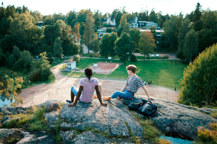Två pojkar sitter på en klippa i en park.