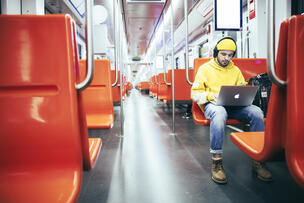Man använder laptop i tunnelbanan