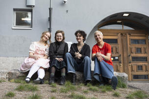 Lukiolaisia istumassa nurmikolla.