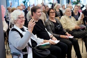 People sitting on chairs at a discussion event.