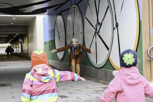Two small children running to the arms of a woman.