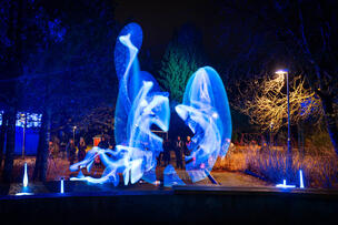 Pimeässä illassa otettu kuva, jossa värillisiä valoja ja liikettä.