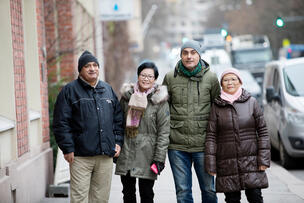 Neljä ihmistä seisoo kadulla vierekkäin