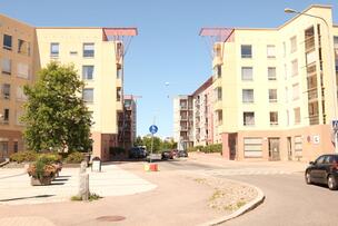 Aukio vaaleankeltaisten kerrostalojen edessä.