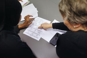  Two people looking at papers.