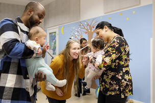 Two small children are enjoying a music event with their parents.