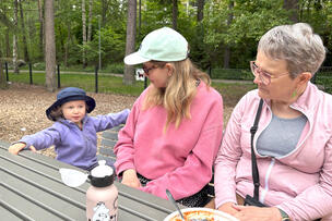 Tre generationer äter på lekplatsen