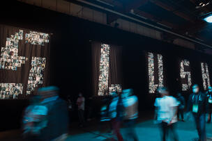 The Slush logo with human figures in front of it.