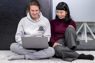 Två personer som tittar på en bärbar dators skärm