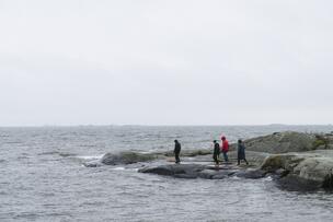 Ihmisiä rantakallioilla.