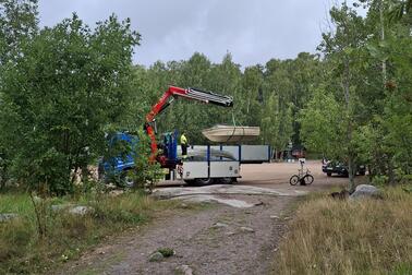 Hylättyjä veneitä siirretään kuorma-autoihin.