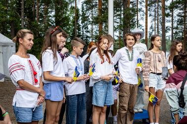 Українська молодь у літньому таборі серед лісу.