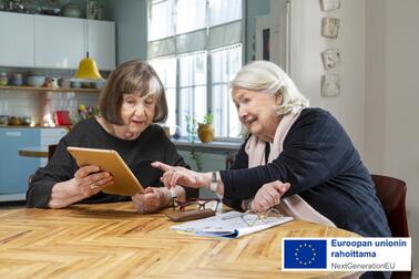 Two elderly women are viewing a tablet PC.