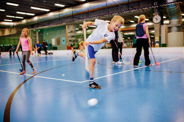 Barnen spelar innebandy.