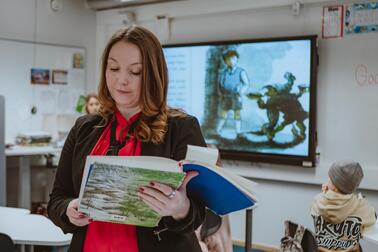 Klasslärare Sonja Lyly läser ur bok i klassrum