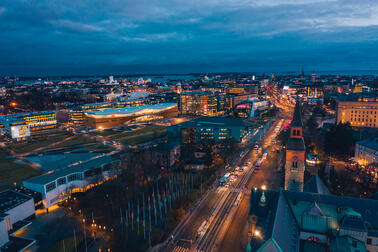 Flygfoto över Helsingfors centrum i skymningen. Nationalmuseet och Finlandiahuset i förgrunden.