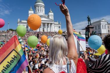 Ihmisiä on kokoontunut Senaatintorille sateenkaarilippujen kanssa