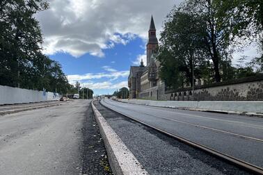 Mannerheimintien työmaa-aluetta elokuussa Finladia-talon kohdalla. Maassa asfalttia ja uudet kiskot kulkevat kuvan keskeltä oikeaan alakulmaan. Taustalla näkyy Kansallismuseo.