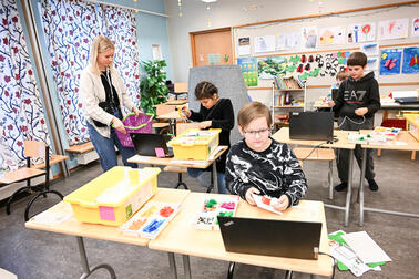 The robotics club meets in a classroom at Vuoniitty Comprehensive School. Three children and an adult.