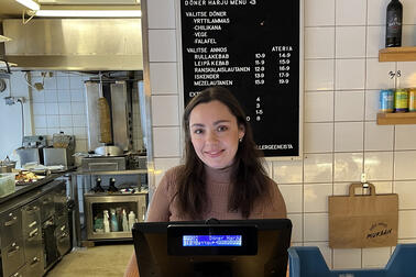 Kateryna Hun stands behind the restaurant's customer desk.