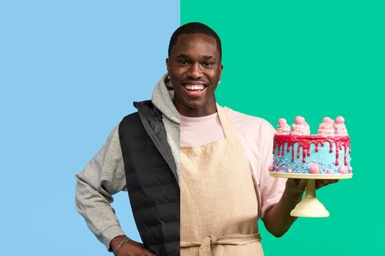 Iloinen nuori mies itsetehty hieno kakku kädessä