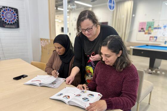 opettaja auttaa KOTIVA-tunnilla opiskelijaa tehtävän tekemisessä..