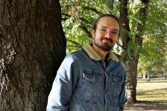 Sijaisperheen isä Topi nojaa puuhun.