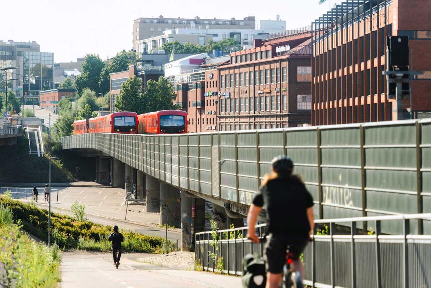 Junatien metrosilta, pyöräilijä ja kävelijä.