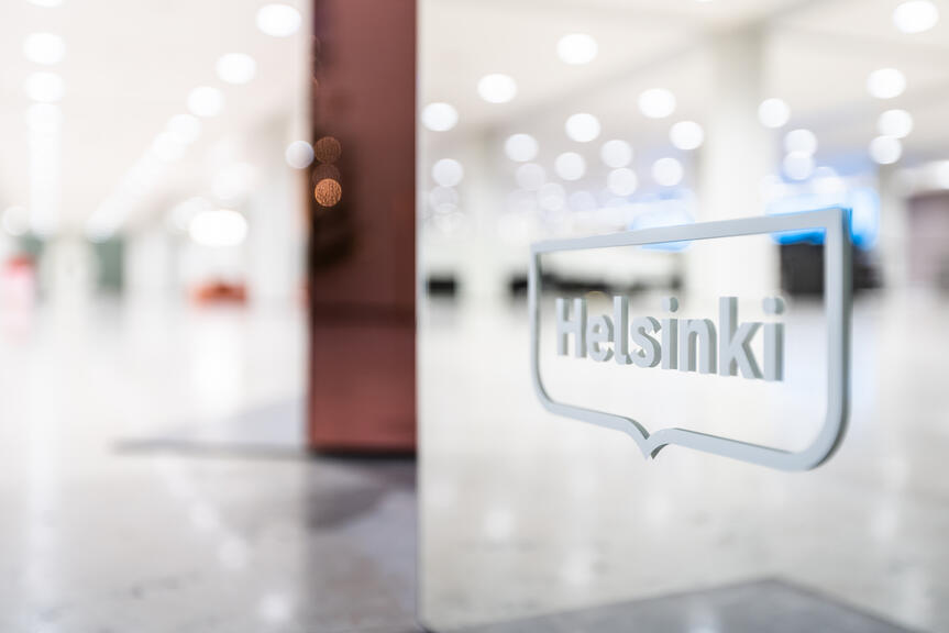 Sisäkuva Helsingin kaupungintalolta. Etualalla Helsinki-logo.