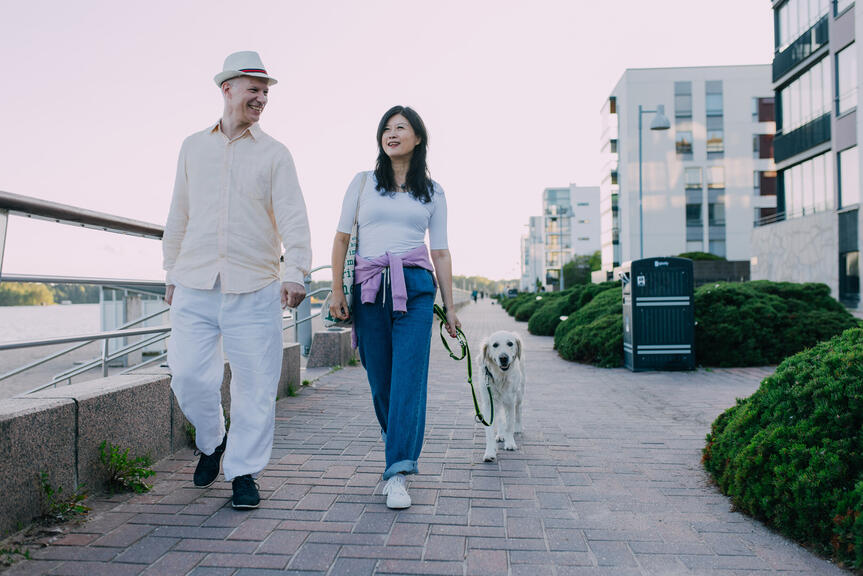 Mies ja nainen kävelevät koiran kanssa Aurinkolahdessa