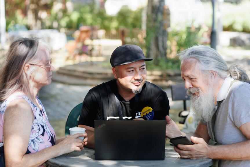 Three people sitting and talking.