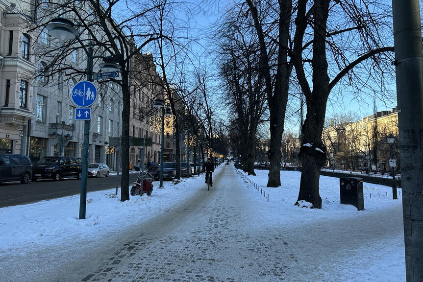 Talvinen katunäkymä ja pyöräilijä.