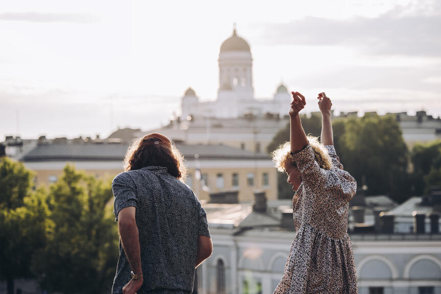 Iloisia ihmisiä, taustalla Helsinkiä ja Tuomiokirkko.