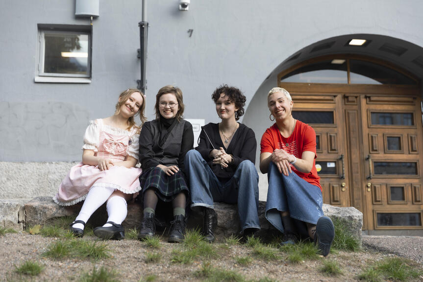 Lukiolaisia istumassa nurmikolla.