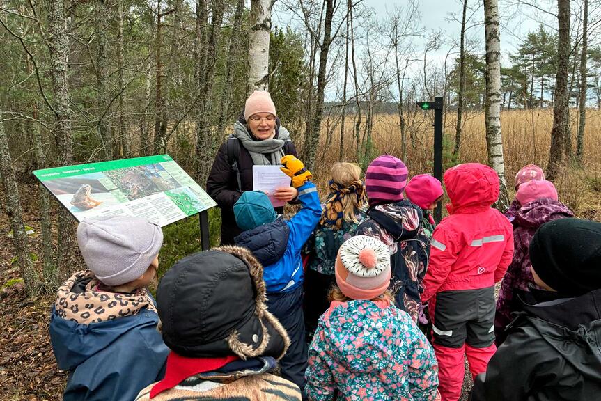 Lapsia herppipolulla opastaulun luona.