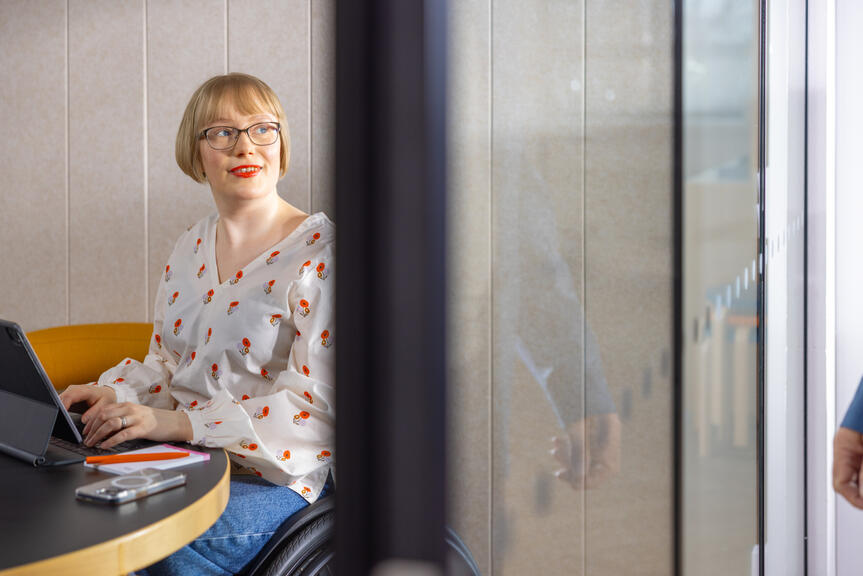 Nainen istuu pyörätuolissa.