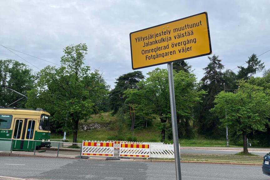 Poistettu suojatie on merkitty väliaikaisilla aidoilla ja kyltillä. 