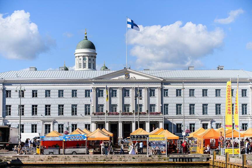 Helsingin kaupungintalo, taustalla näkyy Tuomiokirkkoa ja etualalla Kauppatorin myyntikojuja.