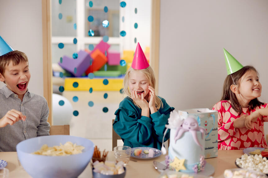 Iloiset lapset viettävät syntymäpäiväjuhlia leikkipuiston tiloissa.