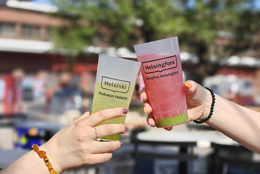 Kaksi kättä pitelee mukeja.