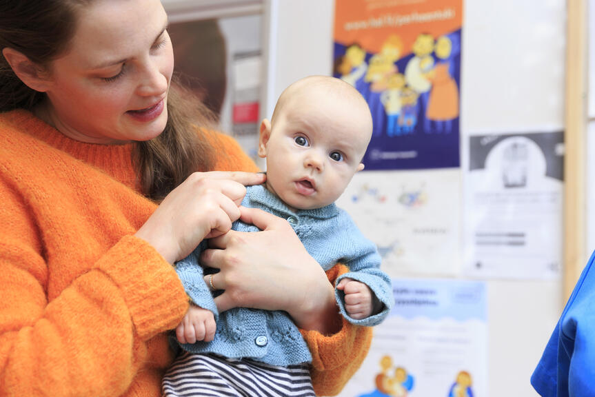 Vauva äidin sylissä.