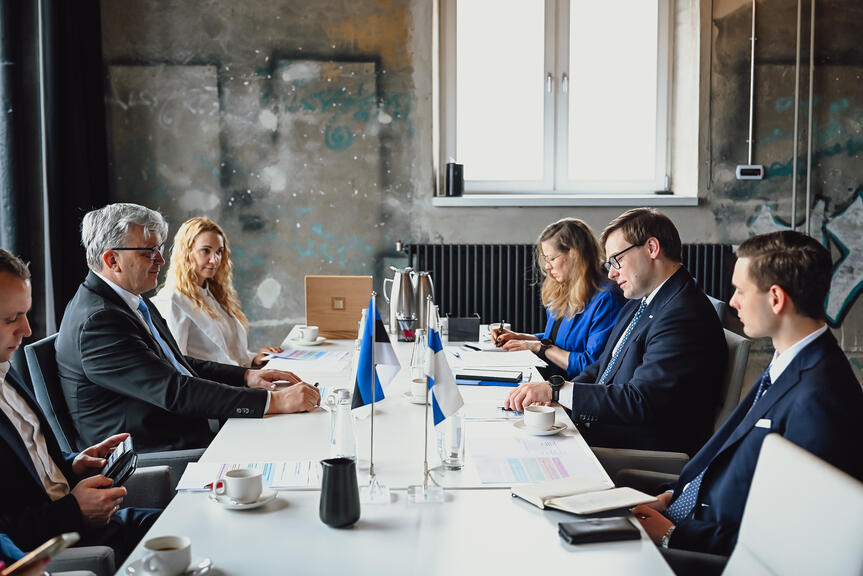 Pormestarit ja muut osallistujat istumassa pöydän ääressä