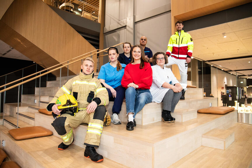 Sosiaali-, terveys- ja pelastustoimen ammattilaisia istumassa yhteiskuvassa.