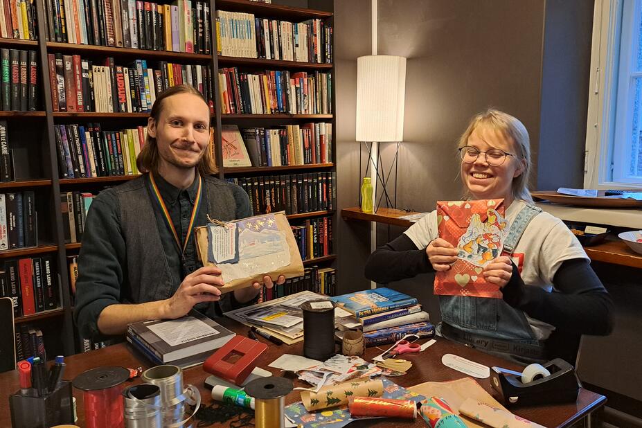 Kirjaston työntekijät paketoivat lahjoja.