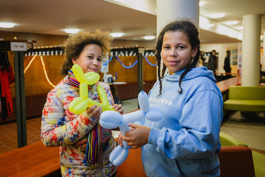 Kaksi tyttöä ilmapallokoirien kanssa